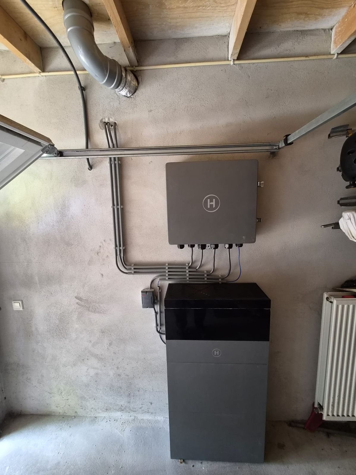 Thuisbatterij met omvormer in een garage, aangelegd door Salm & Helm