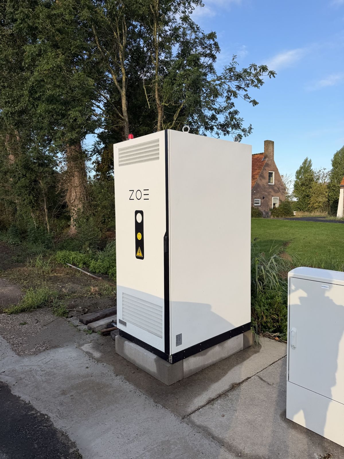 Batterijkast op een betonplaat aan de rand van het erf