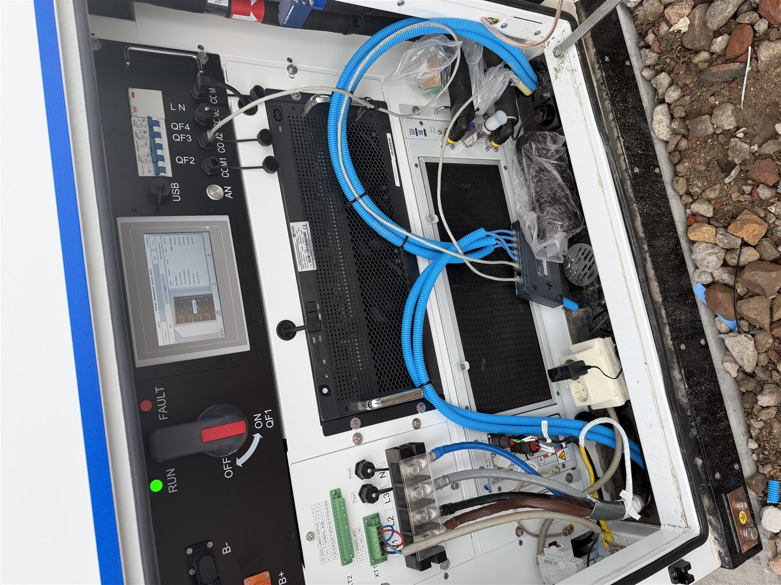 Geopende batterijkast met bedieningspaneel en bekabeling