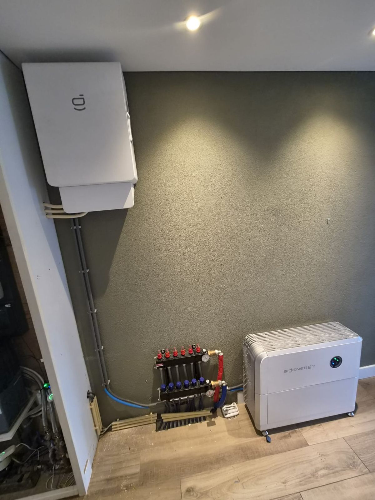 Thuisbatterij aan de wand in een technische ruimte, naast de meterkast